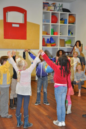 Kinderen in een kring met armen omhoog